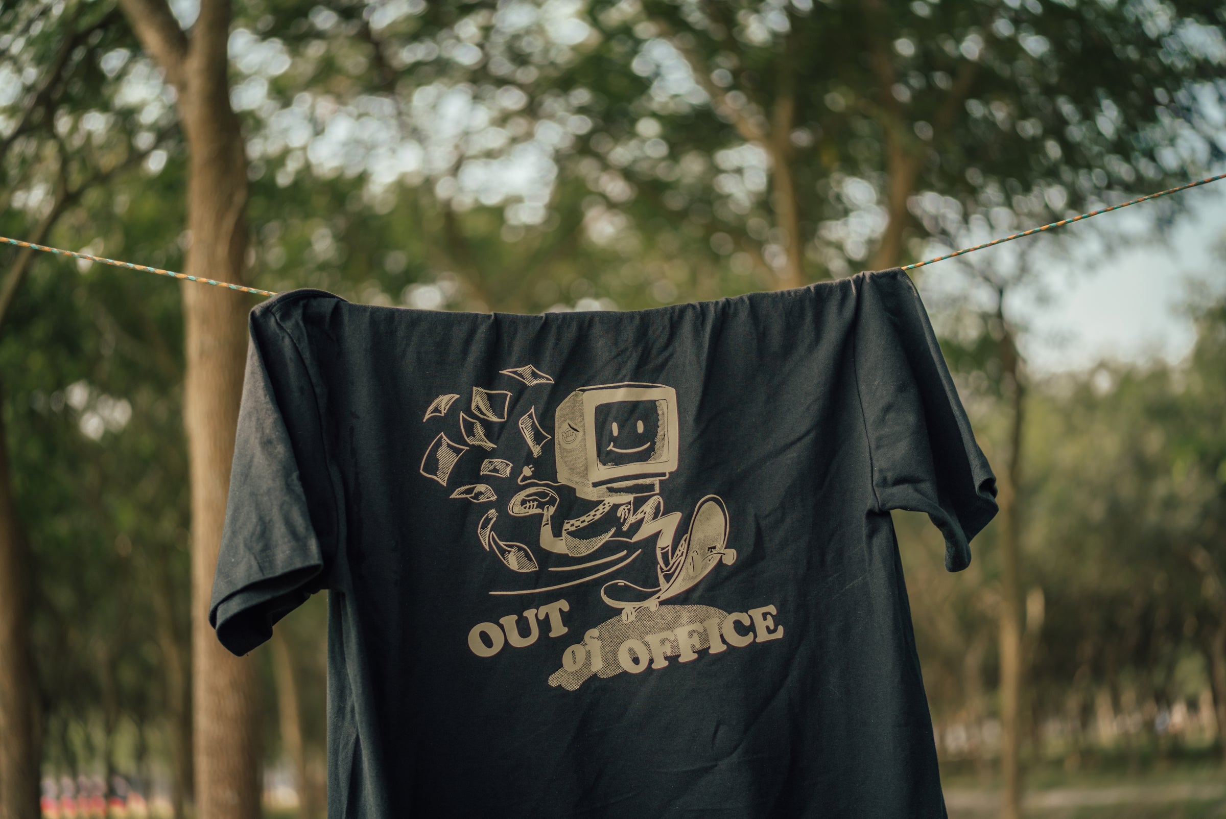 black graphic tee hanging on laundry line
