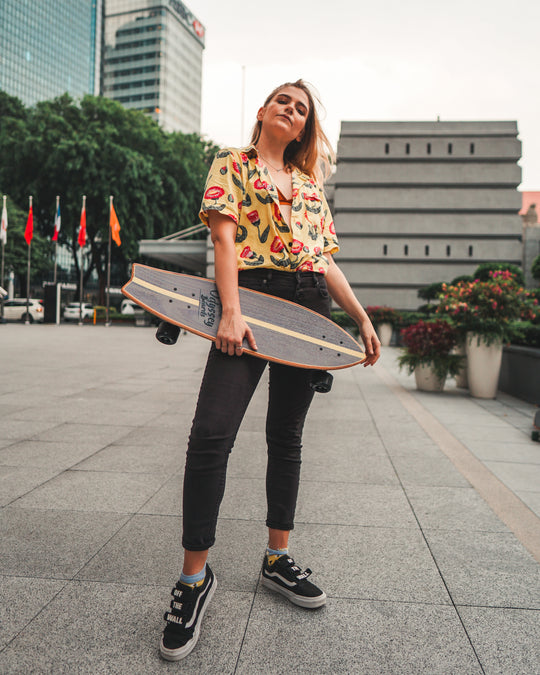 Caucasian lady holding cruiser board in city