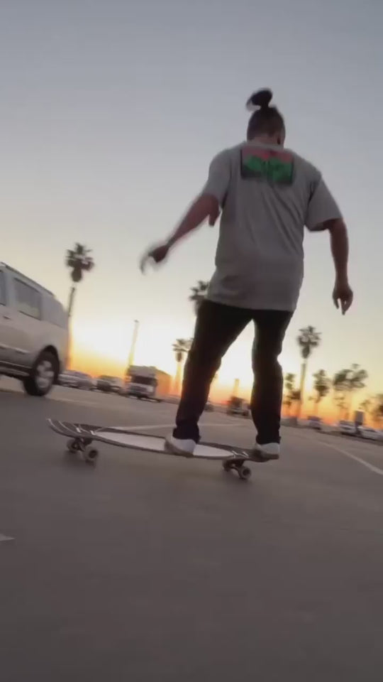 man dancing and freestyle longboard tricks in the sunset